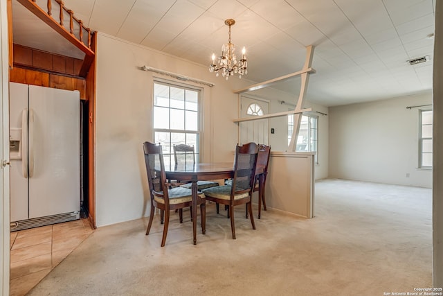 dining room with light carpet and an inviting chandelier