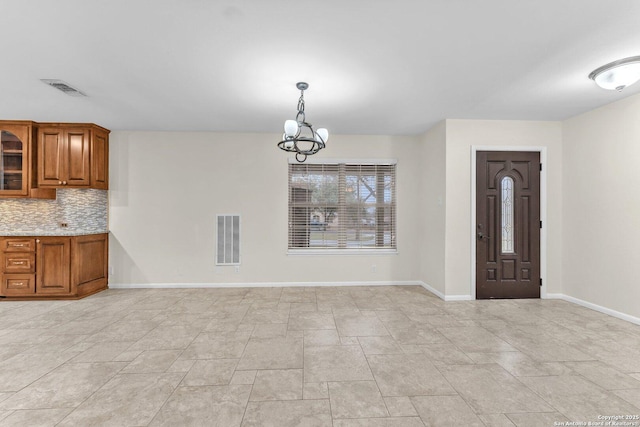 unfurnished dining area featuring a chandelier