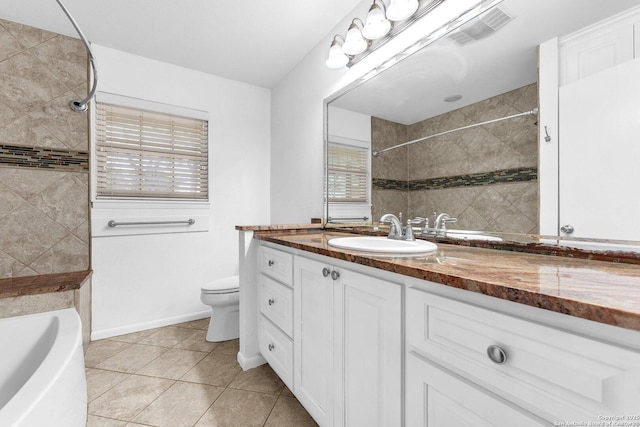 bathroom with vanity, toilet, tile patterned flooring, and plenty of natural light