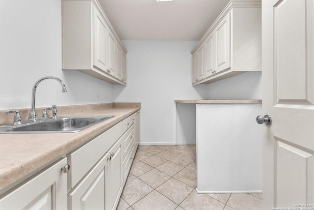 kitchen featuring white cabinetry, sink, and light tile patterned floors