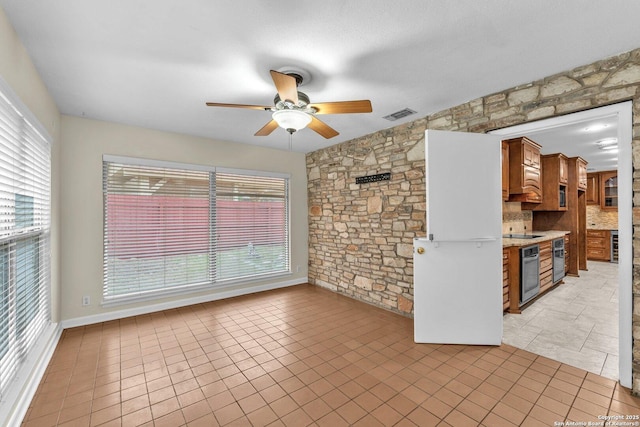 tiled spare room with ceiling fan