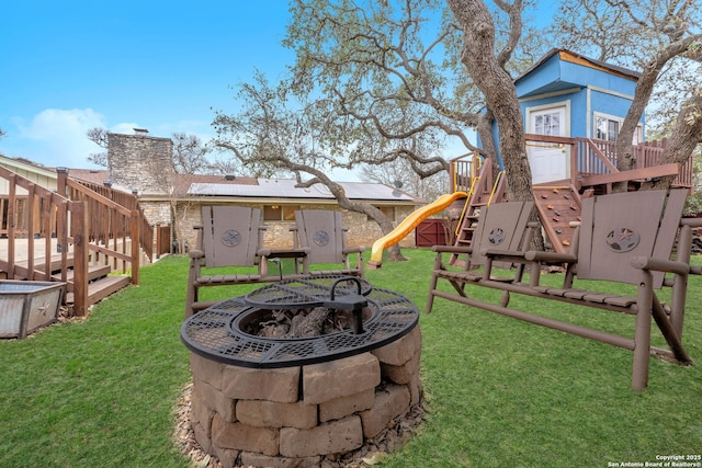 view of yard with a playground and an outdoor fire pit