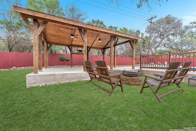 view of yard with ceiling fan, a patio area, and a fire pit