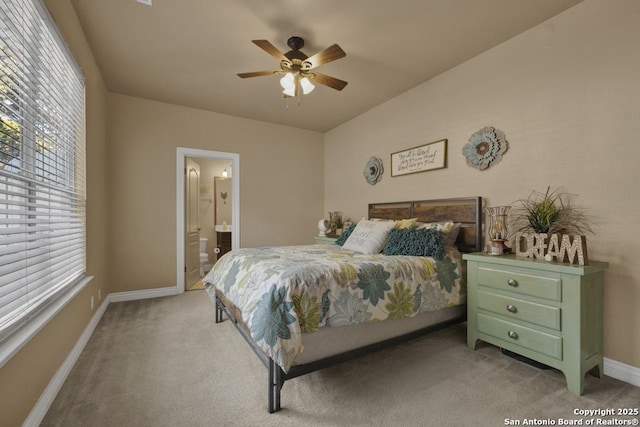 bedroom featuring light carpet, ensuite bath, and ceiling fan