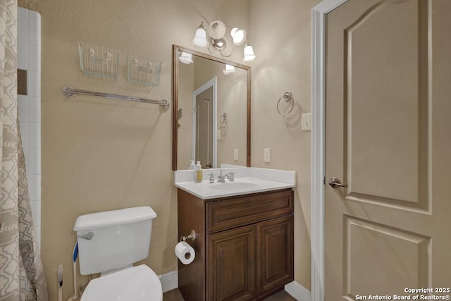 bathroom with vanity, toilet, and curtained shower