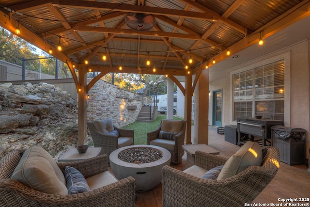 view of patio featuring a gazebo and an outdoor living space with a fire pit