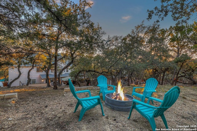 yard at dusk featuring a fire pit