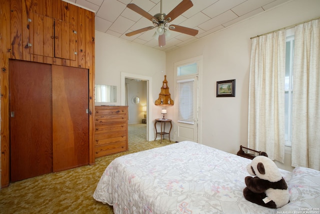 bedroom with multiple windows, light carpet, ceiling fan, and a closet