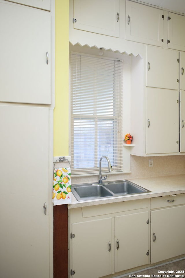 kitchen with white cabinetry and sink