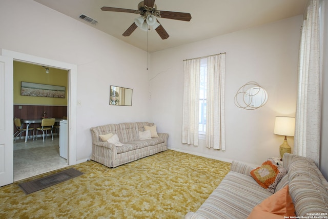 carpeted living room with ceiling fan