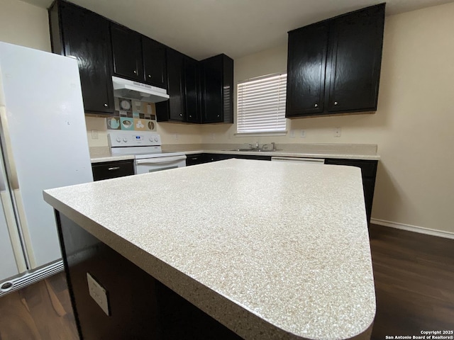 kitchen with white appliances, dark hardwood / wood-style floors, sink, and a kitchen island