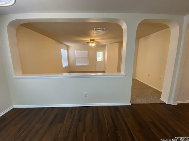 empty room with dark wood-type flooring and ceiling fan