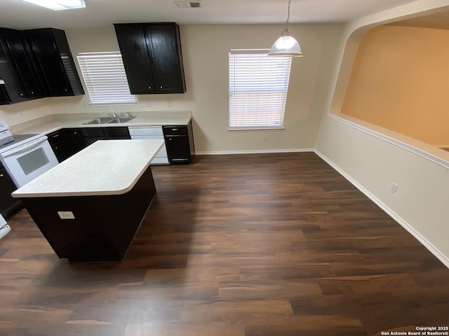 kitchen featuring pendant lighting, sink, white appliances, dark hardwood / wood-style floors, and a kitchen island