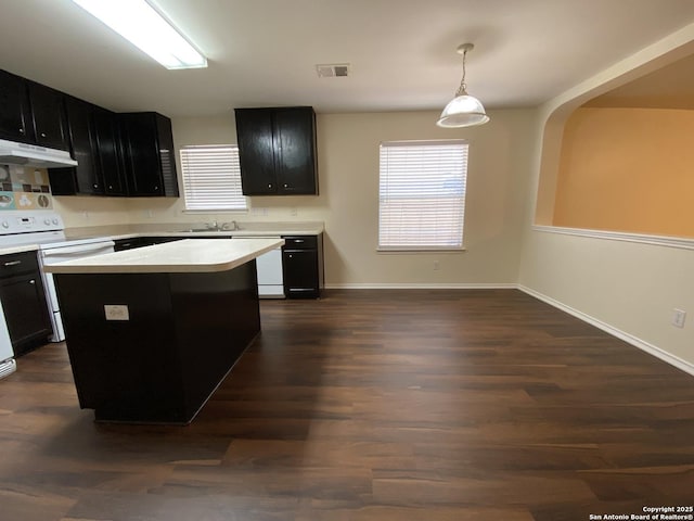 kitchen with dark hardwood / wood-style floors, sink, hanging light fixtures, a center island, and white appliances