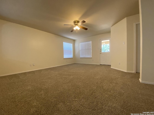 empty room featuring dark colored carpet and ceiling fan