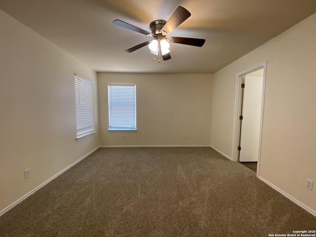 empty room featuring ceiling fan and dark carpet