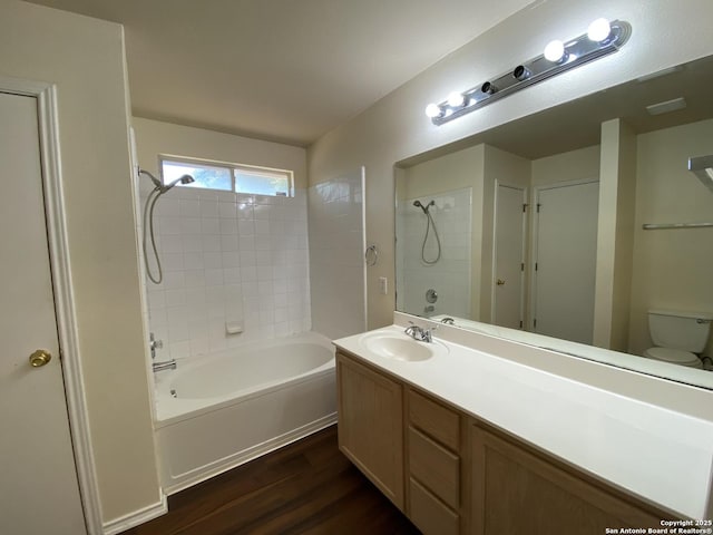 full bathroom featuring vanity, wood-type flooring, toilet, and tiled shower / bath