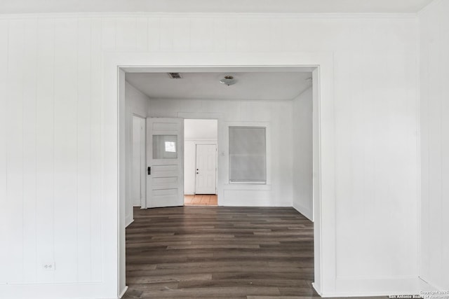 hallway with ornamental molding and dark hardwood / wood-style floors