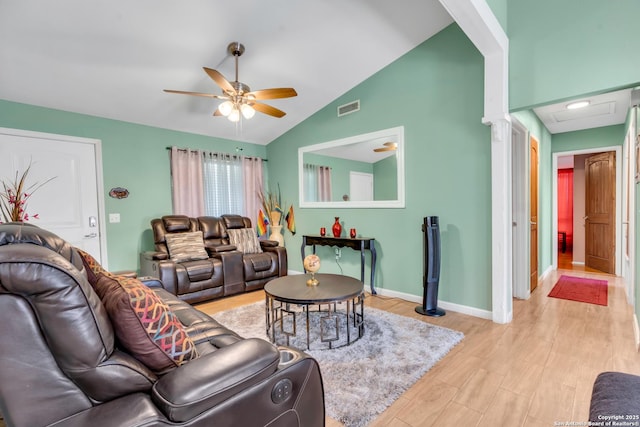 living room with ceiling fan, vaulted ceiling, and light wood-type flooring