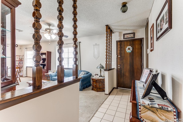 entrance foyer featuring ceiling fan, light carpet, and a textured ceiling