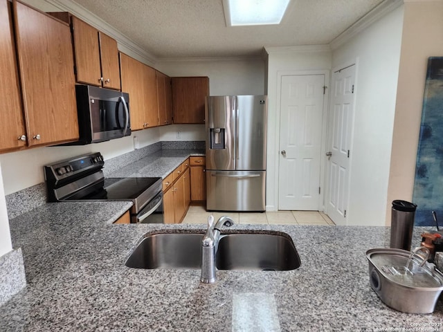 kitchen with sink, a textured ceiling, light tile patterned floors, ornamental molding, and stainless steel appliances