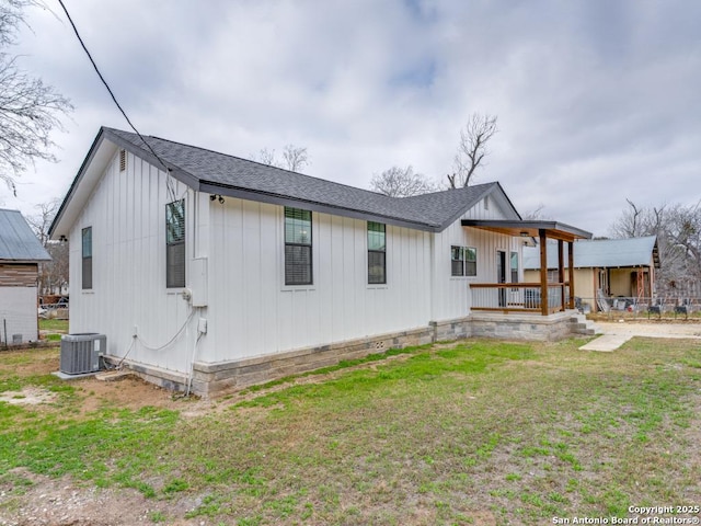 view of front of property with a front yard, central air condition unit, and a porch