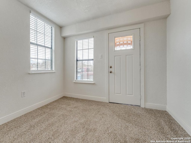 carpeted entryway featuring a textured ceiling