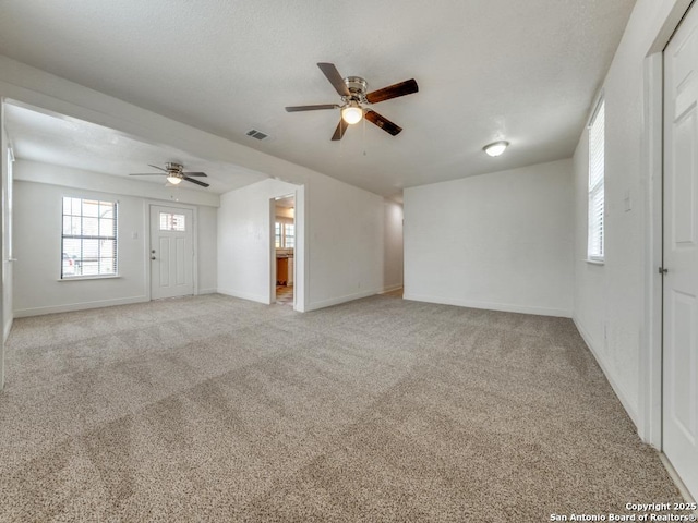 unfurnished living room featuring light carpet and ceiling fan