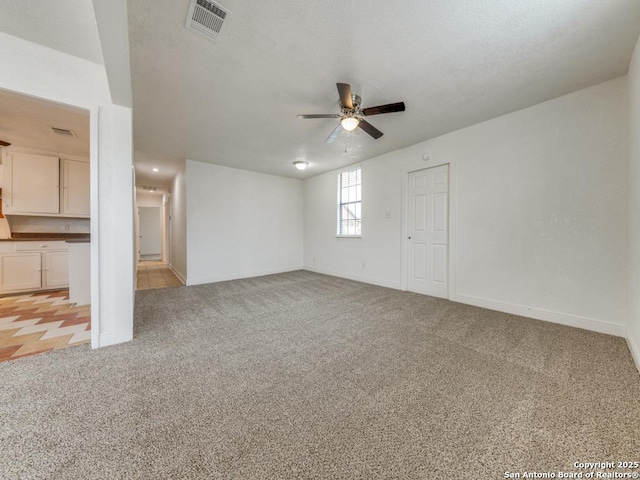 interior space with ceiling fan and light colored carpet