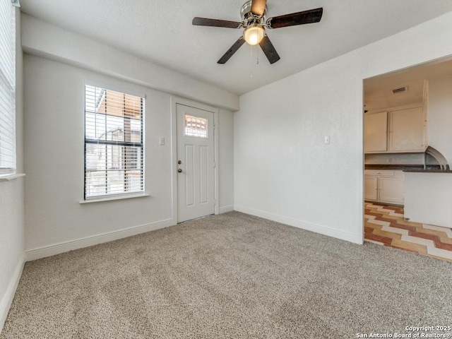 entryway featuring light colored carpet and ceiling fan