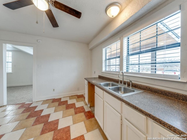 kitchen featuring white cabinetry, ceiling fan, lofted ceiling, and sink