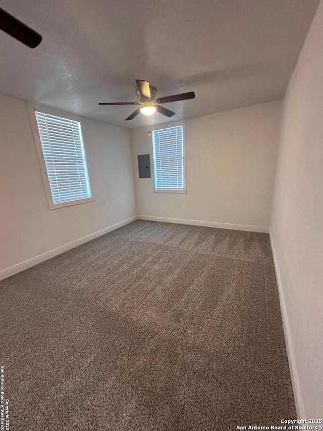 empty room with carpet, a textured ceiling, ceiling fan, and electric panel