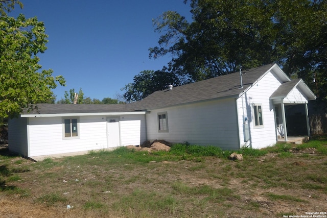 rear view of property featuring a yard