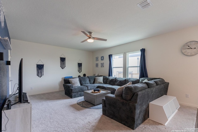 carpeted living room with ceiling fan and a textured ceiling