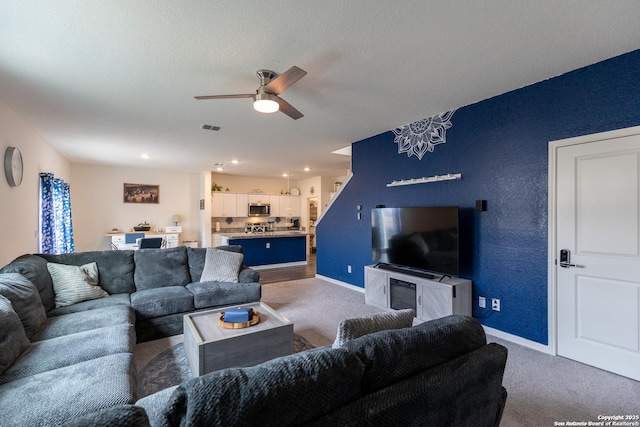 carpeted living room with ceiling fan