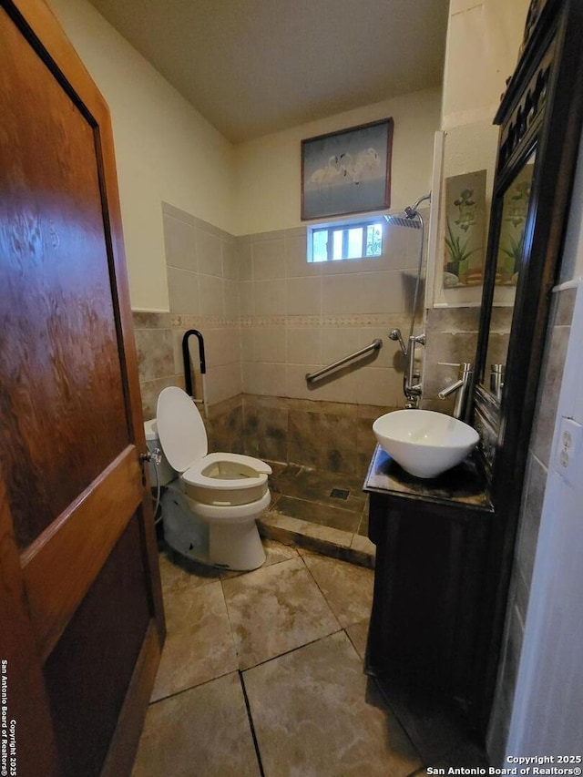 bathroom with tile patterned floors, vanity, toilet, and tile walls