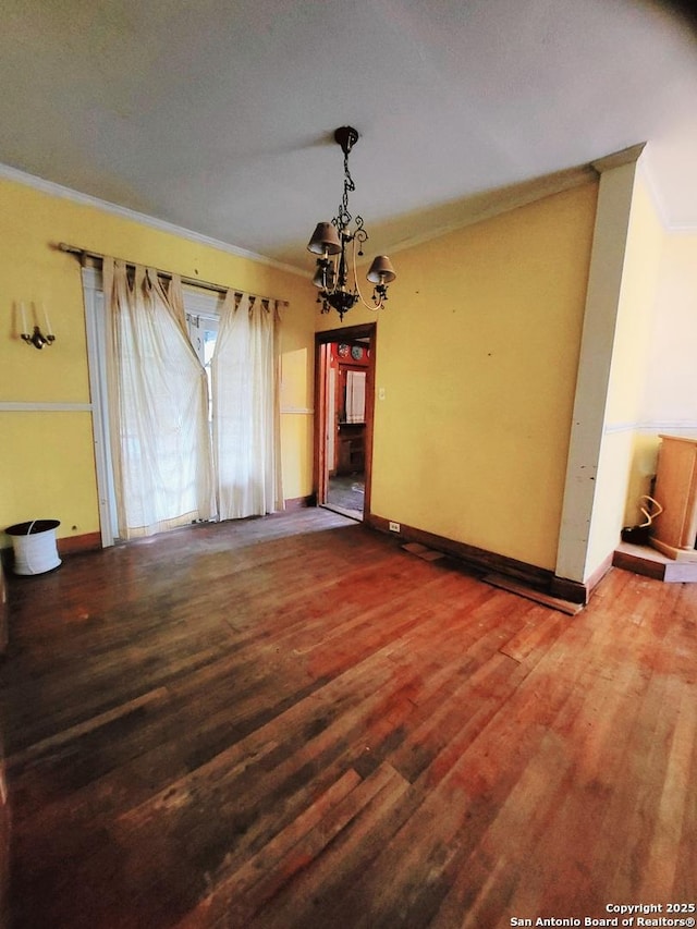 unfurnished dining area with an inviting chandelier, crown molding, and wood-type flooring