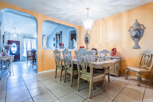 tiled dining area with ceiling fan with notable chandelier