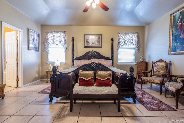 tiled bedroom featuring lofted ceiling, ceiling fan, and a textured ceiling