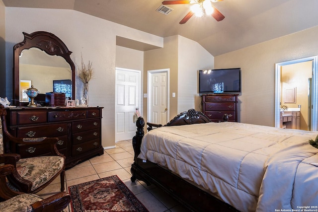 tiled bedroom with vaulted ceiling, connected bathroom, and ceiling fan