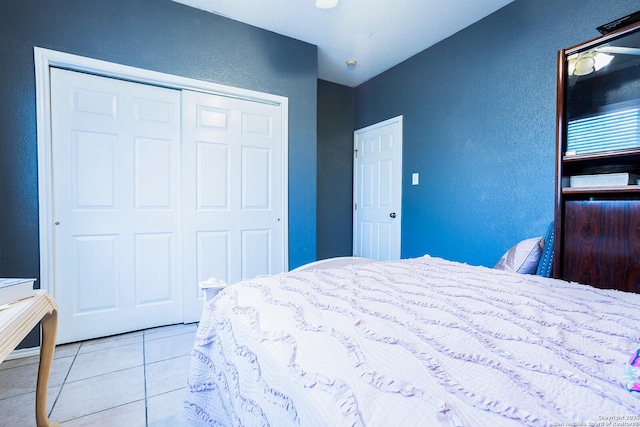 bedroom with light tile patterned floors and a closet