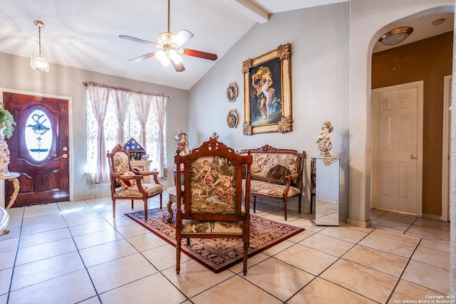 living area with light tile patterned flooring, ceiling fan, and vaulted ceiling with beams