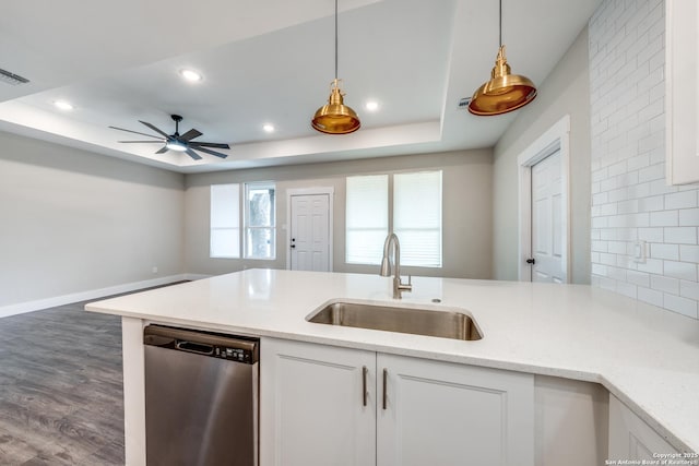 kitchen featuring sink, stainless steel dishwasher, a raised ceiling, and white cabinets