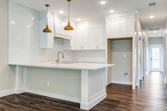 kitchen with dark hardwood / wood-style floors, white cabinetry, sink, hanging light fixtures, and kitchen peninsula