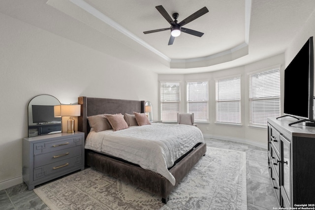 bedroom with a tray ceiling, ornamental molding, and ceiling fan