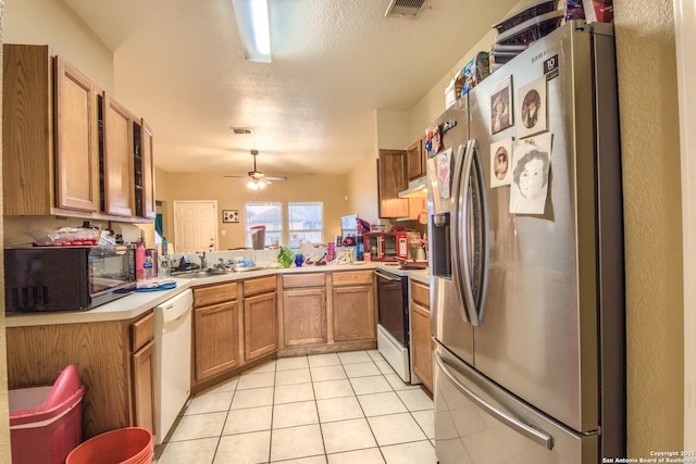 kitchen featuring light tile patterned floors, white appliances, ceiling fan, a textured ceiling, and kitchen peninsula