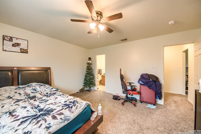 bedroom featuring light carpet, ensuite bath, and ceiling fan