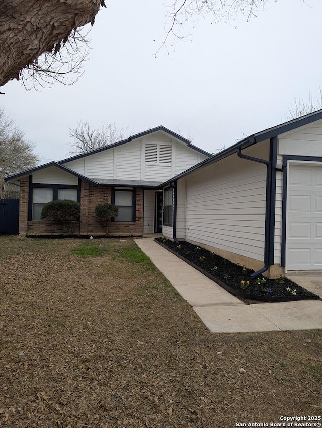 ranch-style home with a garage and a front lawn