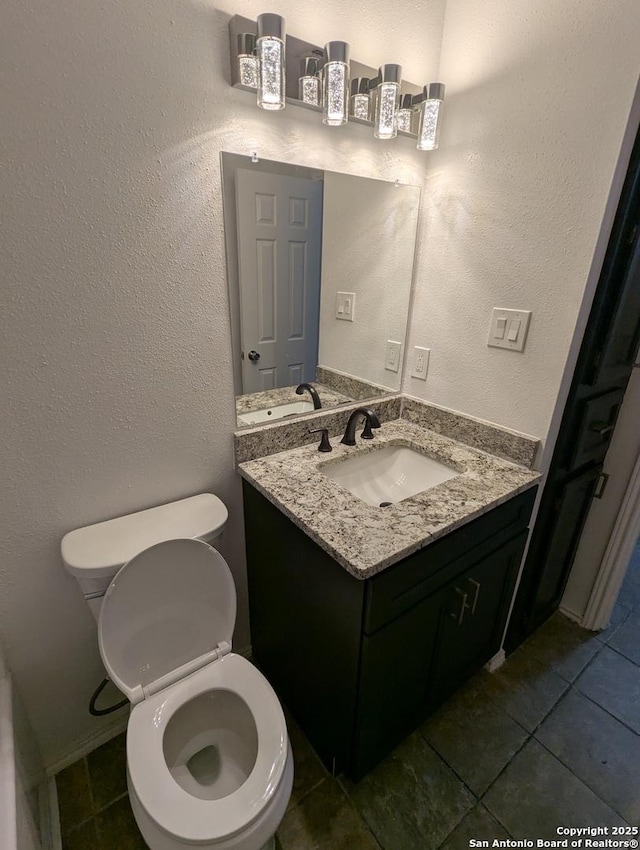 bathroom featuring vanity, tile patterned floors, and toilet