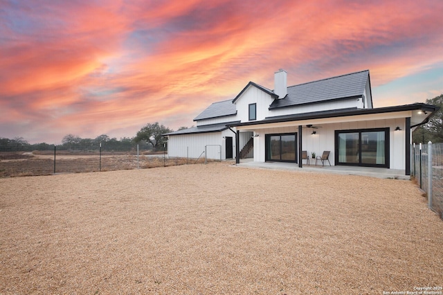 back house at dusk with a patio